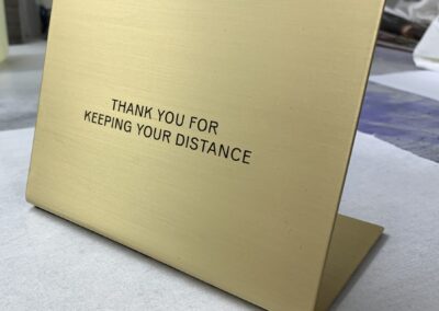 Etched and folded brass table notice